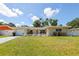 Charming single-story home featuring a well-manicured front yard, attached garage, and inviting entryway at 1445 Wilson Rd, Clearwater, FL 33755