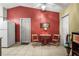 View of kitchen with tile flooring, red wall, white appliances, table with two chairs, and a ceiling fan at 1445 Wilson Rd, Clearwater, FL 33755