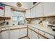 Bright kitchen featuring white cabinets and light-colored counters, with a view from the window at 1445 Wilson Rd, Clearwater, FL 33755