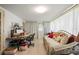 Bright sun room with a wicker sofa, desk, and plenty of natural light from large windows draped with curtains at 1445 Wilson Rd, Clearwater, FL 33755
