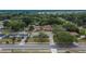 An aerial view shows the home with a tree-lined street and mature trees surrounding the property and other houses at 1607 Melodie Dr, Brandon, FL 33510