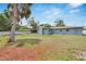 The well-maintained backyard includes a screened-in porch, mature trees, and a fire pit, all enclosed with privacy fencing at 1607 Melodie Dr, Brandon, FL 33510