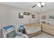 This cozy Bedroom features a wooden crib, comfortable chair, and nature-themed decor, creating a calming and inviting space at 1607 Melodie Dr, Brandon, FL 33510