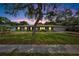 Charming single-story home featuring a well-maintained lawn and mature tree during twilight at 1607 Melodie Dr, Brandon, FL 33510