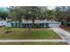 A lovely single-story home with beautiful landscaping is framed by a mature tree in the front yard at 1607 Melodie Dr, Brandon, FL 33510