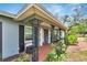 Covered front porch with wrought-iron details and colorful landscaping at 1607 Melodie Dr, Brandon, FL 33510