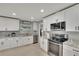 Bright kitchen features white cabinets, stainless steel appliances, and granite countertops at 1607 Melodie Dr, Brandon, FL 33510