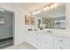 Bright bathroom features double vanity, modern lighting, and a luxurious walk-in shower reflected in the expansive mirror at 16206 Nottingham Park Way, Tampa, FL 33647