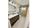 Modern bathroom featuring a wooden vanity, large mirror, and a glass-enclosed shower with a built-in bench at 16206 Nottingham Park Way, Tampa, FL 33647