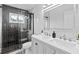 Modern bathroom with double vanity, illuminated mirror, and tiled shower with glass door at 16206 Nottingham Park Way, Tampa, FL 33647