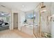 Bright bathroom with tub, separate shower, a window and view into the main bedroom at 16206 Nottingham Park Way, Tampa, FL 33647