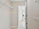 Bright walk-in closet with built-in white wire shelves and a view into the bathroom at 16206 Nottingham Park Way, Tampa, FL 33647