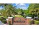 Club Tampa Palms brick entrance with lush landscaping and pond view adds to the community's serene and welcoming atmosphere at 16206 Nottingham Park Way, Tampa, FL 33647