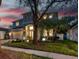 Charming two-story home with a well-manicured lawn and garden featuring spherical decorative lights at 16206 Nottingham Park Way, Tampa, FL 33647