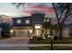 Beautiful two-story home boasting an attached two-car garage, brick driveway, and manicured landscaping at dusk at 16206 Nottingham Park Way, Tampa, FL 33647