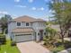 Well-maintained two-story home with a brick driveway, attached garage, and beautifully landscaped front yard at 16206 Nottingham Park Way, Tampa, FL 33647