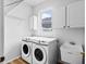 Bright laundry room with washer, dryer, and utility sink, and white cabinets at 16206 Nottingham Park Way, Tampa, FL 33647