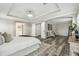Large main bedroom with white tray ceiling, ensuite entrance, and seating area with wood-look flooring at 16206 Nottingham Park Way, Tampa, FL 33647