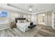 Light and bright main bedroom featuring tray ceilings, wood floors, a modern ceiling fan and ensuite at 16206 Nottingham Park Way, Tampa, FL 33647