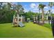 Community playground with swings, slides, and climbing structures, set on artificial turf, offers safe outdoor activities at 16206 Nottingham Park Way, Tampa, FL 33647