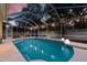 Screened-in pool area with turquoise-colored water and decorative lights for evening swims and relaxation at 16206 Nottingham Park Way, Tampa, FL 33647