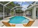 Relaxing screened-in pool area with modern lounge chairs and a lush backyard at 16206 Nottingham Park Way, Tampa, FL 33647