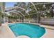 Inviting screened-in pool featuring a waterfall feature, lush backyard and mature trees at 16206 Nottingham Park Way, Tampa, FL 33647