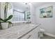 Elegant bathroom featuring granite countertops, white cabinetry, and a decorative orchid to enhance the space's ambiance at 2002 Waikiki Way, Tampa, FL 33619