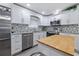 Modern kitchen featuring stainless steel appliances, white cabinetry, and a mosaic backsplash for style and function at 2002 Waikiki Way, Tampa, FL 33619