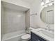 Well-lit bathroom featuring tiled shower-over-tub, modern vanity with marble countertop, and round mirror at 208 Danube Ave # 101, Tampa, FL 33606