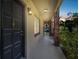 Inviting entrance with a black door and a covered walkway framed by brick columns and lush greenery at 208 Danube Ave # 101, Tampa, FL 33606