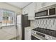 Updated kitchen features stainless steel appliances and a marble tile backsplash at 208 Danube Ave # 101, Tampa, FL 33606