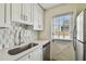 Bright kitchen with white cabinets, stainless steel appliances, and tiled backsplash at 208 Danube Ave # 101, Tampa, FL 33606