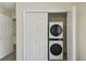 A compact laundry closet with stacked washer and dryer units, neatly concealed by white folding doors at 208 Danube Ave # 101, Tampa, FL 33606
