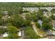 An aerial view of a residential area with a mix of homes, mature trees, and a nearby pond and community pool at 2222 Euclid N Cir, Clearwater, FL 33764