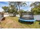 Spacious backyard featuring a trampoline and a white privacy fence for Gathering enjoyment at 2222 Euclid N Cir, Clearwater, FL 33764