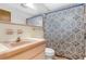 Bathroom features a vintage blue and white patterned shower curtain, and pink tiling around a vanity at 2222 Euclid N Cir, Clearwater, FL 33764