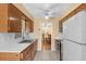 Open kitchen design with wood cabinets, laminate countertops, a white refrigerator, and tile backsplash at 2222 Euclid N Cir, Clearwater, FL 33764