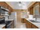 Functional kitchen with wood cabinets, laminate countertops, white appliances, and a ceiling fan at 2222 Euclid N Cir, Clearwater, FL 33764