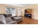 Cozy living room with hardwood floors, a large window, neutral paint, and a comfortable sectional sofa at 2222 Euclid N Cir, Clearwater, FL 33764