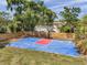 Aerial view of a custom basketball court with a new wooden perimeter fence and beautiful mature trees at 2575 Granada E Cir, St Petersburg, FL 33712