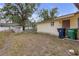 Exterior view of a house, featuring a yard with a shed and trash cans at 2724 W Henry Ave, Tampa, FL 33614