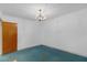 Bedroom with chandelier, minimal window, blue carpeting, and door, ready for customization at 2724 W Henry Ave, Tampa, FL 33614