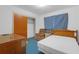 Modest bedroom with wood furnishings, chair and bed, ready for customization at 2724 W Henry Ave, Tampa, FL 33614