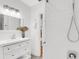 Bright bathroom with a modern vanity, decorative mirror, and a glass enclosed shower featuring white subway tiles at 2859 Dartmouth N Ave, St Petersburg, FL 33713
