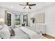 Bright bedroom with hardwood floors, three windows, white walls, neutral furniture, and an art display at 2859 Dartmouth N Ave, St Petersburg, FL 33713