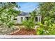 Charming home with lush front yard, palm trees, and modern solar panels on the roof at 2859 Dartmouth N Ave, St Petersburg, FL 33713