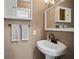 Elegant half-bath features a pedestal sink, decorative mirror and cabinet with stylish lighting at 2859 Dartmouth N Ave, St Petersburg, FL 33713