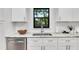 Bright kitchen featuring stainless steel appliances, white cabinets, a marble countertop, and a sleek faucet at 2859 Dartmouth N Ave, St Petersburg, FL 33713