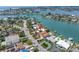 Stunning aerial view of a waterfront home featuring a private dock, lush landscaping, and a serene pool at 31 Dolphin Dr, Treasure Island, FL 33706
